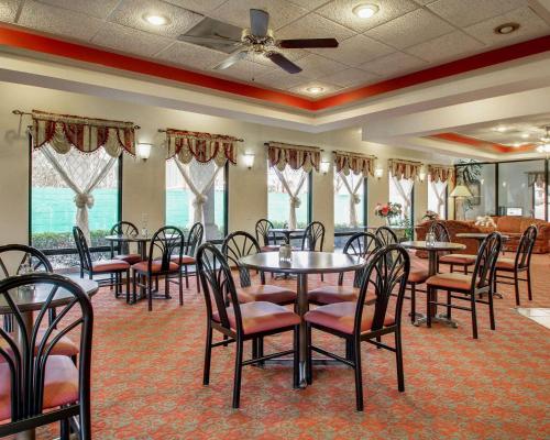 a dining room with tables and chairs and windows at Quality Inn & Suites in Clinton