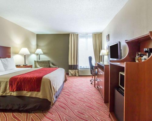 um quarto de hotel com uma cama e uma televisão de ecrã plano em Comfort Inn Poplar Bluff North em Poplar Bluff