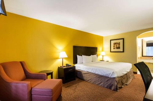 Habitación de hotel con cama y silla en Quality Inn Indianola en Indianola