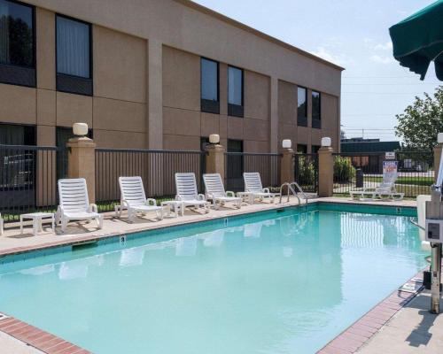 a swimming pool with lounge chairs and a building at Quality Inn Magee in Magee