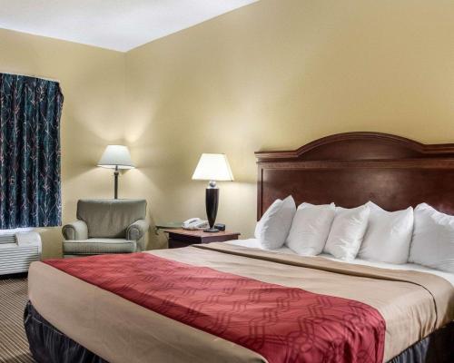 a hotel room with a bed and a chair at Econo Lodge Greenville in Greenville