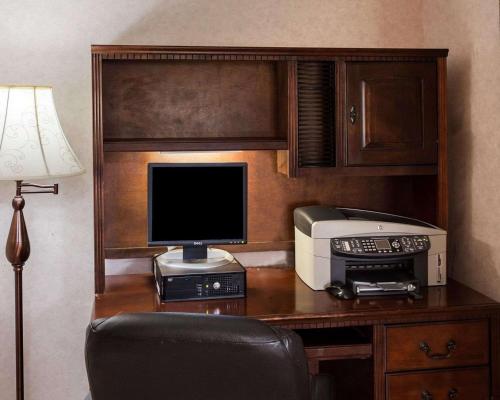a desk with a computer and a printer and a monitor at Quality Inn Robinsonville in Tunica Resorts