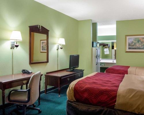 a hotel room with a bed and a desk with a computer at Econo Lodge Canton I-55 in Canton