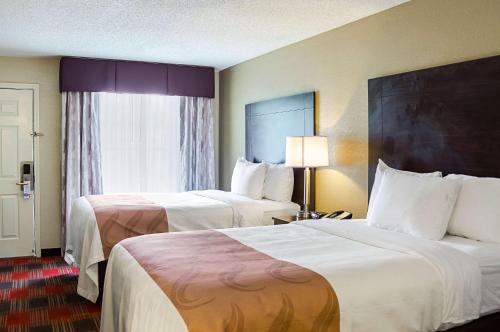 a hotel room with two beds and a window at Quality Inn Vicksburg in Vicksburg