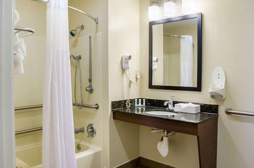 a bathroom with a sink and a shower with a mirror at Quality Inn Vicksburg in Vicksburg