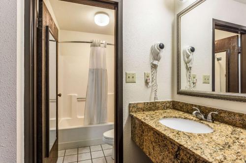 a bathroom with a sink and a toilet and a mirror at Quality Inn Tupelo Central in Tupelo