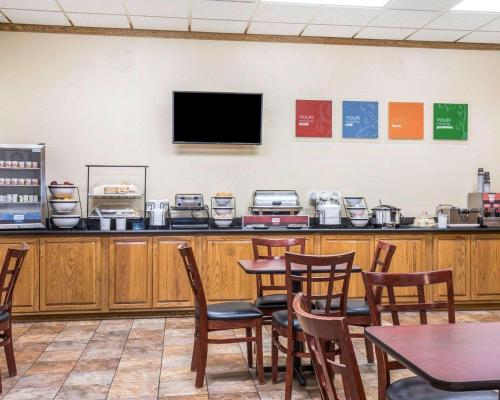 a restaurant with tables and a tv on a wall at FairBridge Inn & Suites Glendive in Glendive