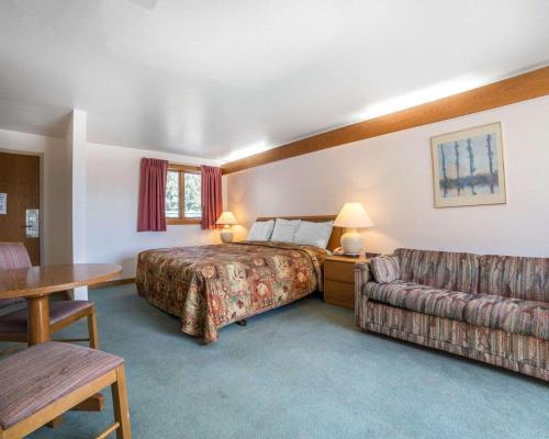 a hotel room with a bed and a couch at Rodeway Inn Billings Logan Intl Airport, Near St. Vincent Hospital in Billings