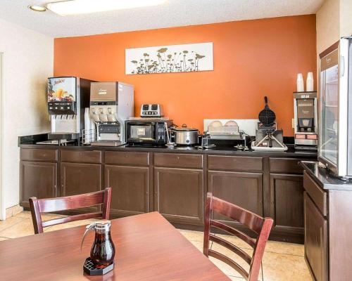 cocina con paredes de color naranja, mesa y sillas en Sleep Inn Billings, en Billings