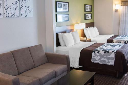 a hotel room with two beds and a couch at Sleep Inn Missoula in Missoula