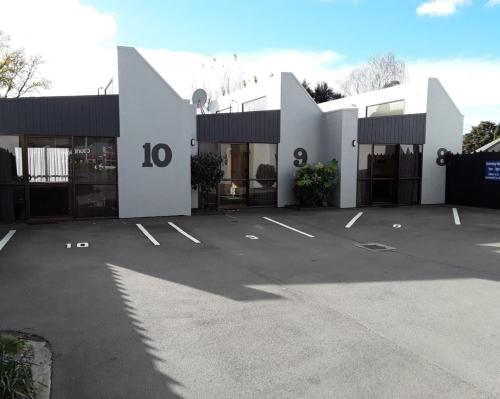 a white building with a parking lot in front of it at Sundowner Motel in Blenheim