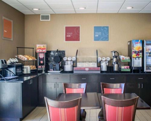 a restaurant with a counter with a table and chairs at Comfort Inn & Suites Fuquay Varina in Fuquay-Varina