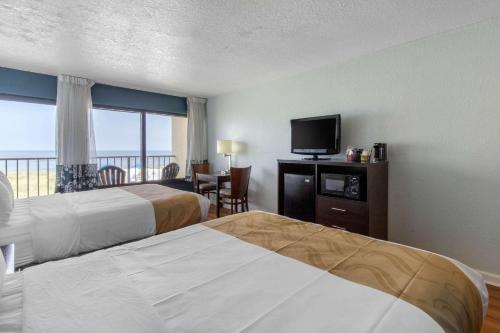 Quality Inn Carolina Oceanfront في كيل ديفيل هيلز: غرفة فندقية بسريرين وتلفزيون بشاشة مسطحة