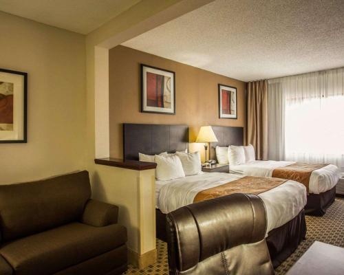 a hotel room with two beds and a couch at Comfort Suites Lumberton in Lumberton