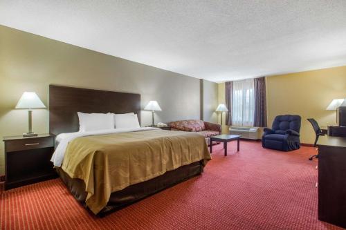 a hotel room with a bed and a chair at Quality Inn Williamston in Williamston