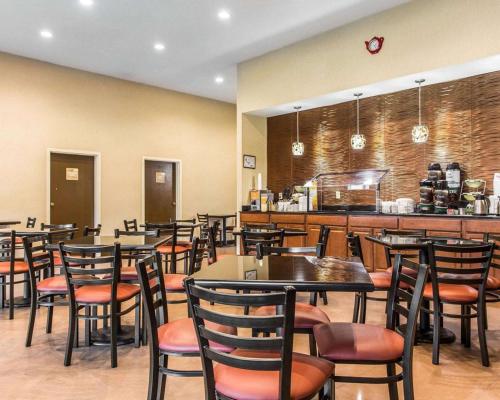 un ristorante con tavoli e sedie e un bar di Quality Suites Convention Center - Hickory a Hickory