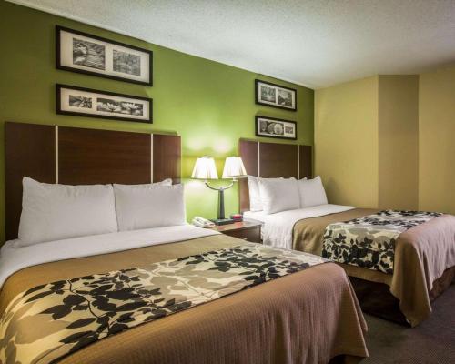 two beds in a hotel room with green walls at Sleep Inn Asheville - Biltmore West in Asheville