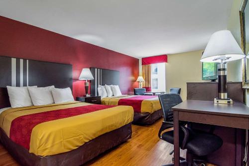ein Hotelzimmer mit 2 Betten und einem Schreibtisch in der Unterkunft Econo Lodge Research Triangle Park in Durham