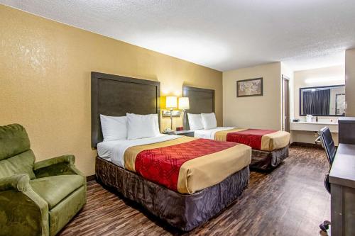 a hotel room with two beds and a chair at Econo Lodge Inn & Suites Matthews - Charlotte in Matthews