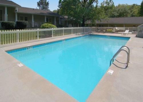 a large blue swimming pool in front of a house at Rodeway Inn & Suites Cherokee On the River in Cherokee