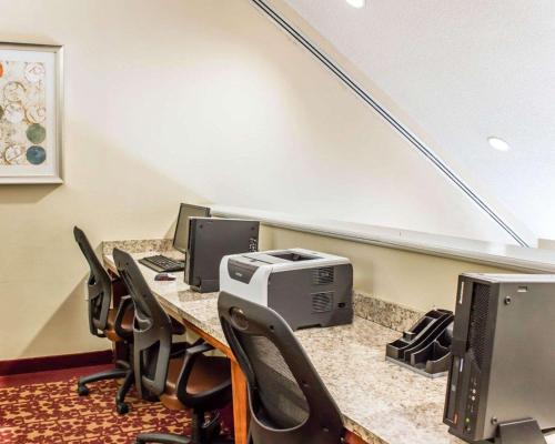 a conference room with a desk with computers and chairs at Comfort Inn Fayetteville near Fort Bragg in Fayetteville