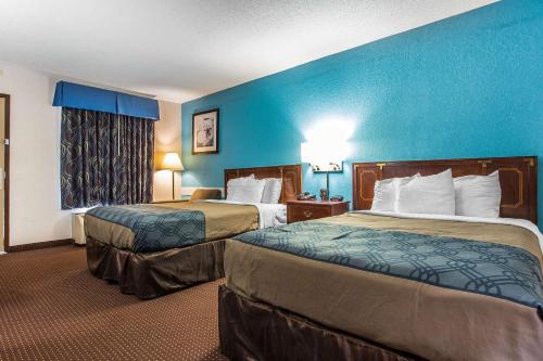 2 camas en una habitación de hotel con paredes azules en Econo Lodge Elizabeth City, en Elizabeth City