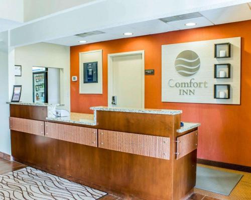 a lobby of a comfort inn with an orange wall at Comfort Inn Fayetteville near Fort Bragg in Fayetteville