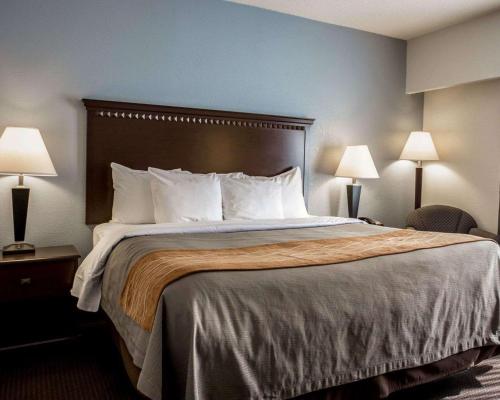 a large bed in a hotel room with two lamps at Comfort Inn & Suites Lumberton Central I-95 in Lumberton