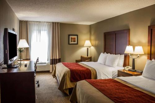 a hotel room with two beds and a flat screen tv at Comfort Inn Research Triangle Park in Durham