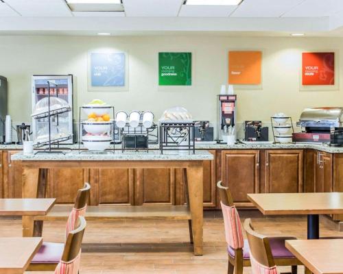 a restaurant with a counter and tables and chairs at Comfort Inn Fayetteville near Fort Bragg in Fayetteville