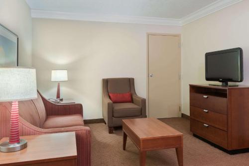 a hotel room with a chair and a television at Comfort Inn Fayetteville near Fort Bragg in Fayetteville