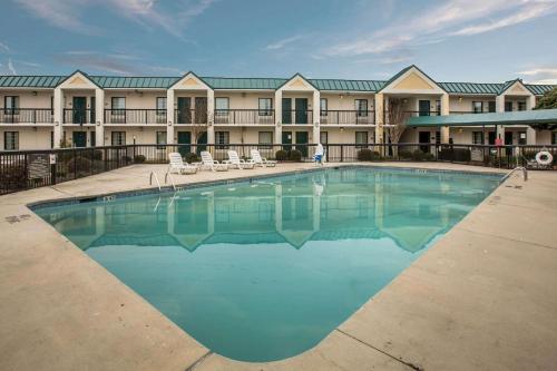 a large pool in front of a hotel with chairs at Quality Inn & Suites Hanes Mall in Winston-Salem