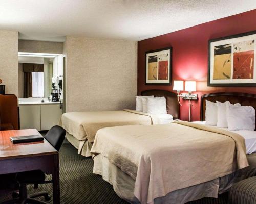 een hotelkamer met 2 bedden en een bureau bij Quality Inn Roanoke near Lake Gaston in Roanoke Rapids