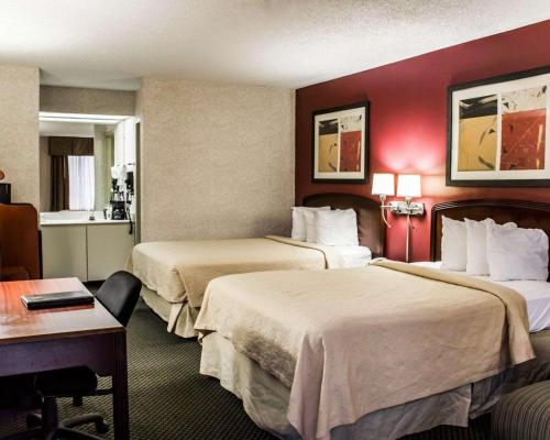 a hotel room with two beds and a desk at Quality Inn Roanoke near Lake Gaston in Roanoke Rapids