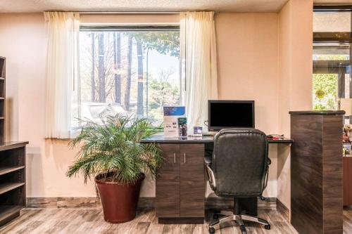 an office with a desk with a computer and a plant at Lake Norman Inn and Suites in Cornelius