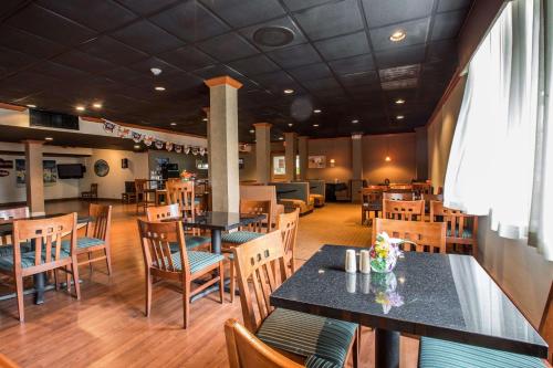 a dining room with tables and chairs in a restaurant at Quality Inn & Suites Hanes Mall in Winston-Salem