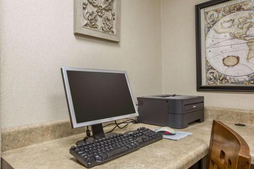 a computer monitor and a printer on a desk at Quality Inn & Suites Hanes Mall in Winston-Salem