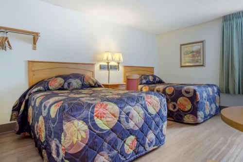 a hotel room with two beds and a table at Rodeway Inn Asheville in Asheville
