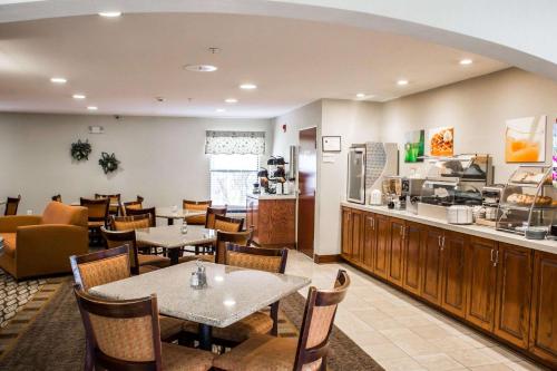 a restaurant with tables and chairs and a counter at Quality Inn Fuquay Varina East in Fuquay-Varina