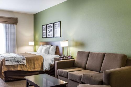 a hotel room with a bed and a couch at Sleep Inn & Suites Mount Olive North in Mount Olive
