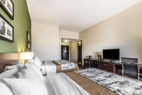 a hotel room with two beds and a flat screen tv at Sleep Inn & Suites Mount Olive North in Mount Olive