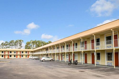 a building with cars parked in a parking lot at Rodeway Inn & Suites Wilmington North in Wilmington