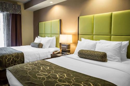 a hotel room with two beds with green headboards at Comfort Suites New Bern near Cherry Point in New Bern