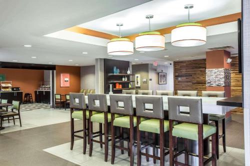 a dining room with a bar with stools at Comfort Inn & Suites Kannapolis - Concord in Kannapolis