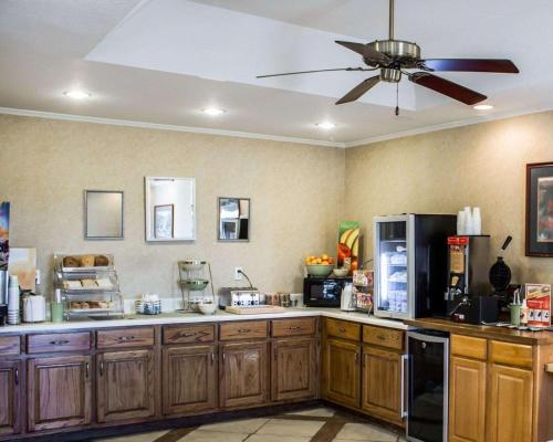 a kitchen with wooden cabinets and a ceiling fan at Quality Inn Goldsboro in Goldsboro