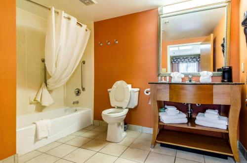 a bathroom with a toilet and a tub and a sink at Quality Inn in Lumberton