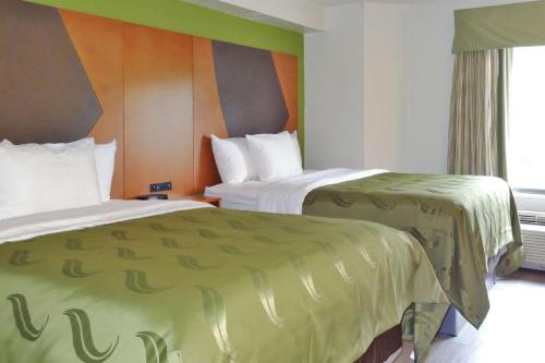 ローリーにあるQuality Inn & Suites Raleigh North Raleighのホテルルーム ベッド2台&緑のシーツ付