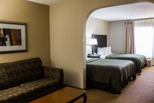 a hotel room with two beds and a chair at Quality Inn & Suites Wilson I-95 in Wilson