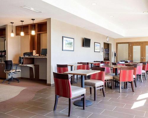 a restaurant with tables and chairs and a bar at Comfort Inn & Suites Watford City in Watford City
