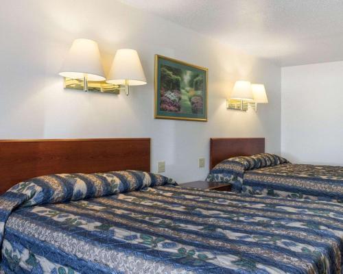 a hotel room with two beds and two lamps at Rodeway Inn in West Fargo